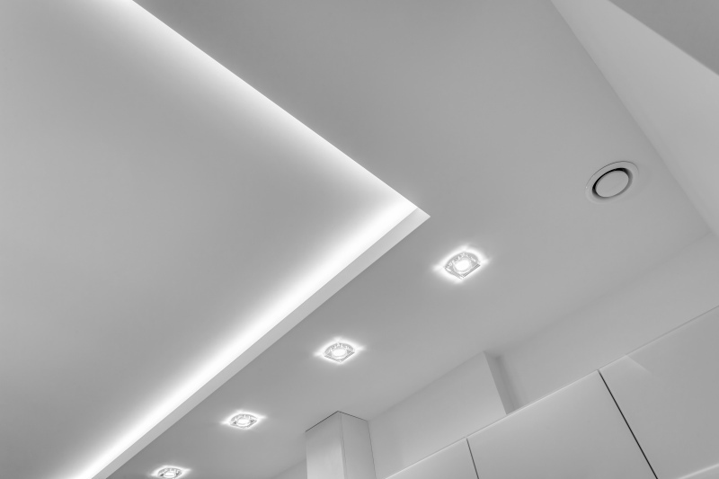 Porady architektów dotyczące wyboru oświetlenia do salonu - lampy sufitowe, listwy LED czy halogeny
